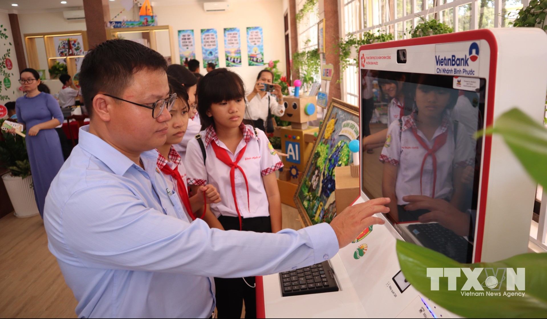 Cán bộ hướng dẫn học sinh trải nghiệm Kiosk dịch vụ công tại không gian đổi mới sáng tạo phường Bình Phước, giúp các em tiếp cận phương thức thực hiện thủ tục hành chính trên môi trường số. (Ảnh: Đậu Tất Thành/TTXVN)